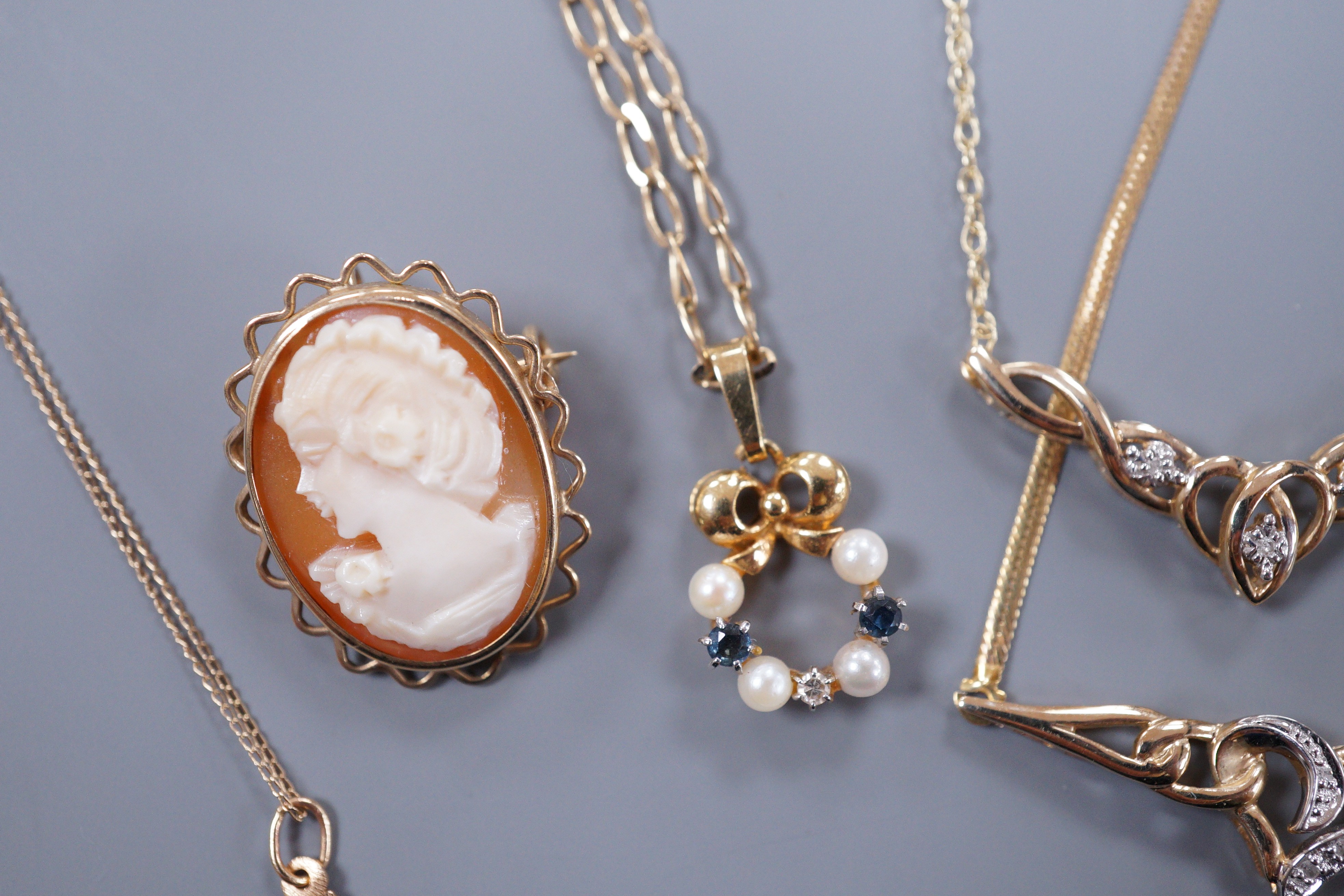 A 9ct gold diamond chip set necklace and matching bracelet, a cross pendant, a sapphire diamond and pearl pendant and a small cameo brooch, gross 11 grams